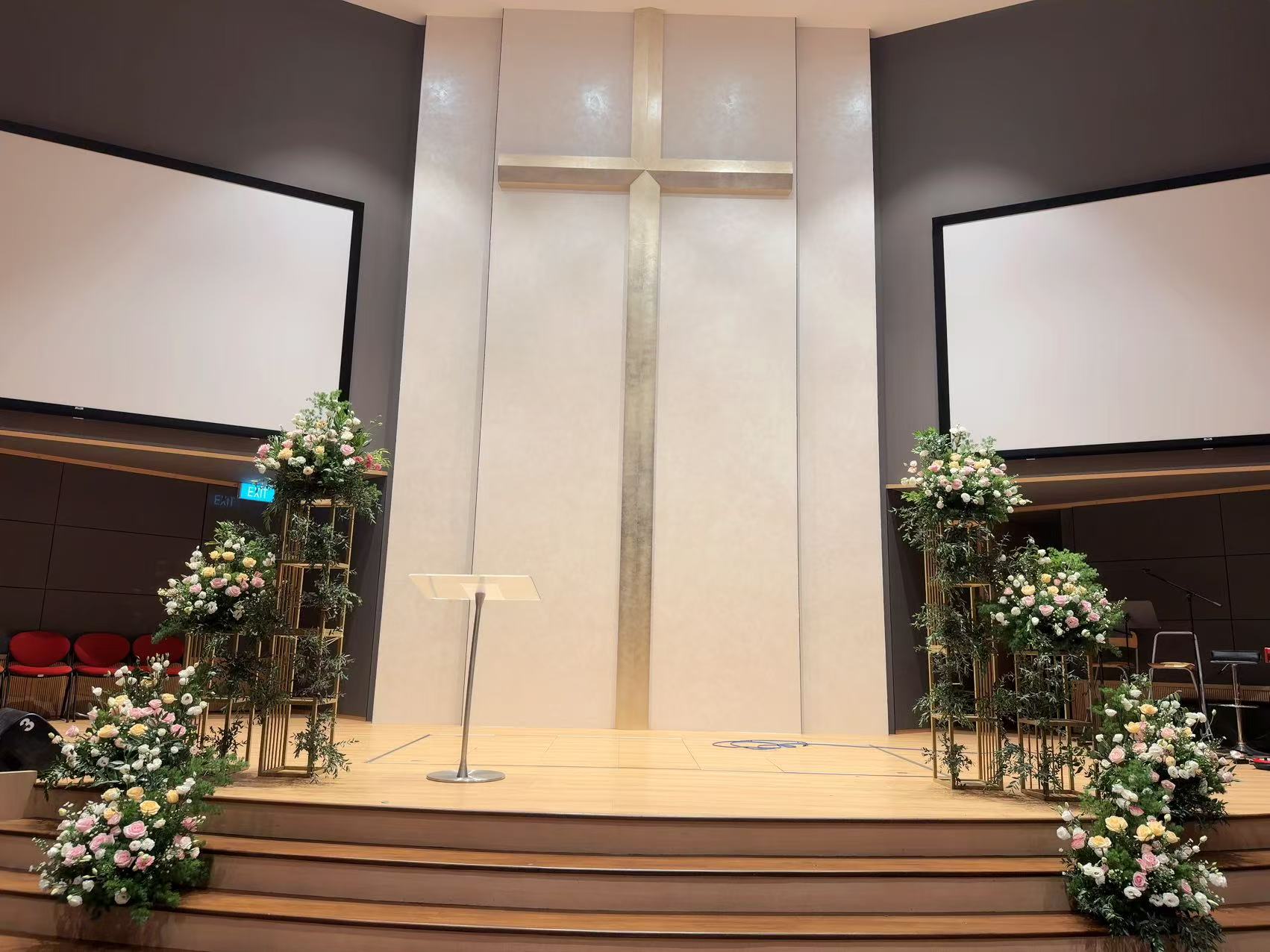 Full stage view framed by gold multi-tiered floral pedestals